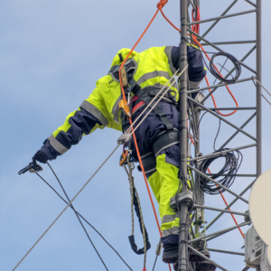 Tekniker med fallsikringsutstyr arbeider i mast i henhold til NS9610 ved arbeid i høyden